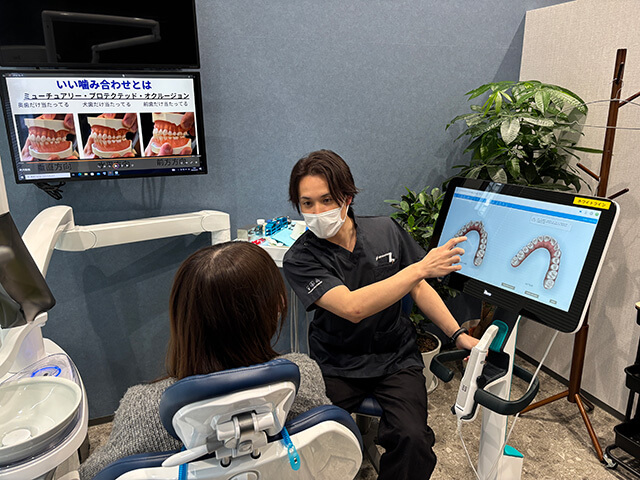 患者様に治療の説明をする歯科医
