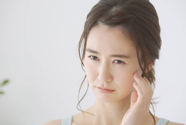 顎に痛みを感じている女性