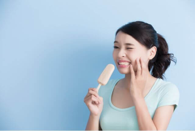 アイスが歯にしみている女性